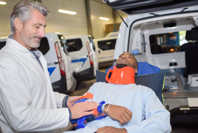 Une personne blessée sur un brancard, accompagné d'un professionnel de santé 